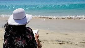 Donna che legge al mare